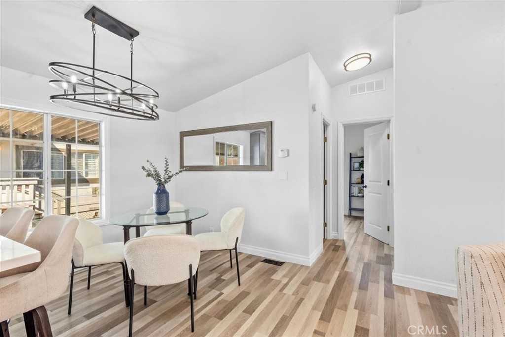 Dining area with a modern light fixture and large windows for natural light. - 9080 Bloomfield Avenue 153, Cypress CA 90630 - photo 9