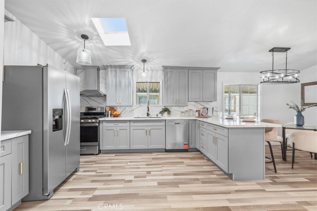 Oversized kitchen with new cabinetry, quartz countertops and a skylight for natural light. - 9080 Bloomfield Avenue 153, Cypress CA 90630 - photo 3