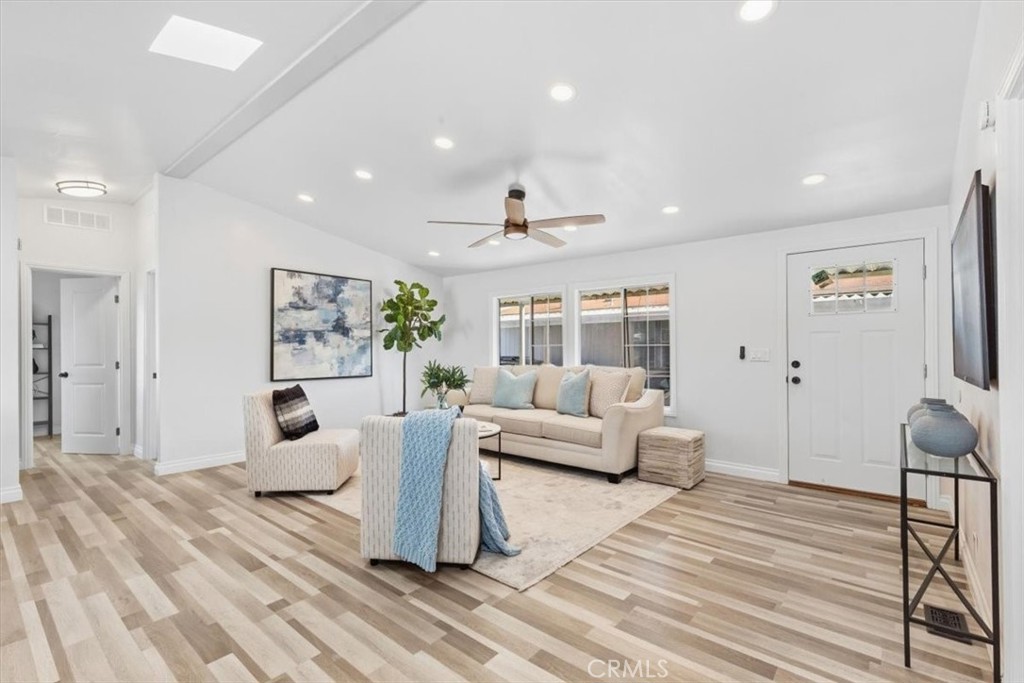 Spacious living room with vaulted ceiling, skylight, ceiling fan and recessed lighting. - 9080 Bloomfield Avenue 153, Cypress CA 90630 - photo 8