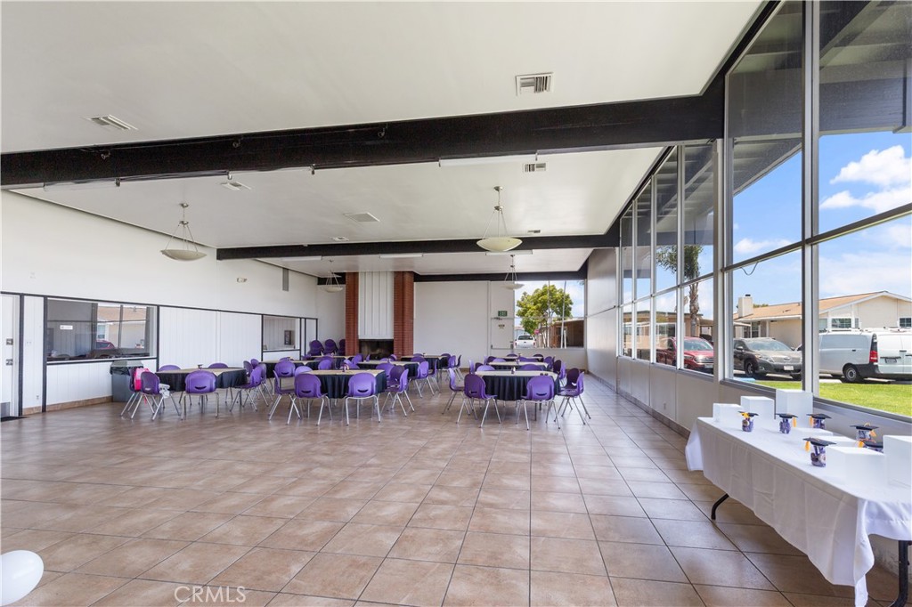 Large event room with floor-to-ceiling windows, a fireplace and seating for gatherings. - 9080 Bloomfield Avenue 153, Cypress CA 90630 - photo 23