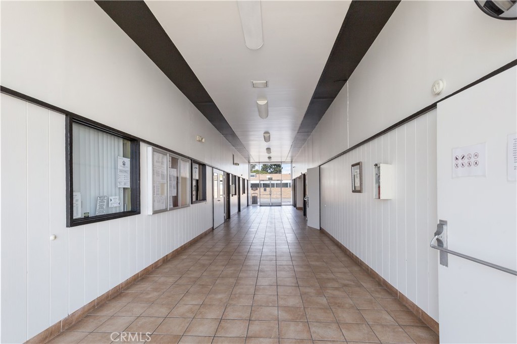 Bright clubhouse hallway with community notice boards. - 9080 Bloomfield Avenue 153, Cypress CA 90630 - photo 24