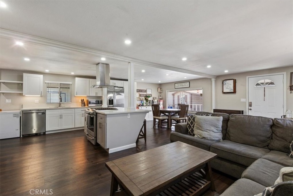 Updated Kitchen: Open island kitchen with white cabinetry, stainless steel appliances, bar seating, recessed lighting, a - 9080 Bloomfield Avenue 293, Cypress CA 90630 - photo 5