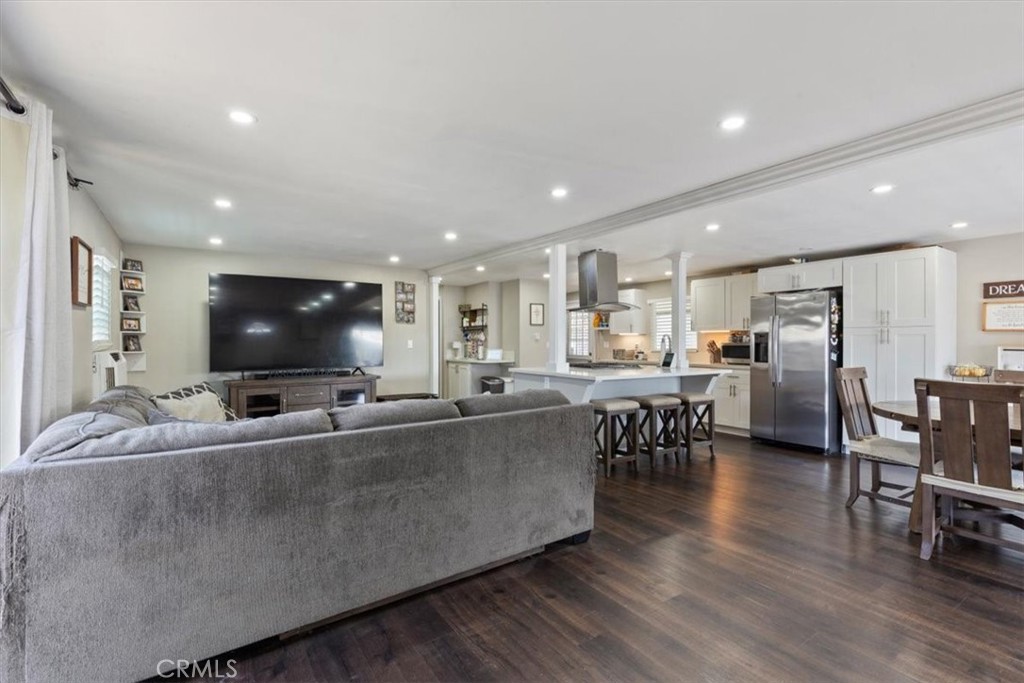 Living Room: Large open living area with updated flooring, recessed lighting, neutral tones, and direct flow to the kitc - 9080 Bloomfield Avenue 293, Cypress CA 90630 - photo 9