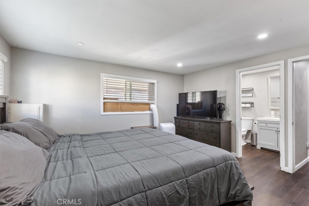 Primary Bedroom: Spacious primary suite with updated flooring, recessed lighting, walk-in closet, and private en suite b - 9080 Bloomfield Avenue 293, Cypress CA 90630 - photo 10
