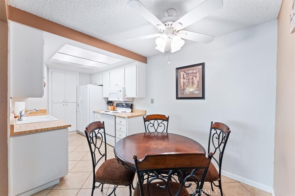 Kitchen and dining area with lighted ceiling fan. - 25611 Quail Run 32, Dana Point CA 92629 - photo 6