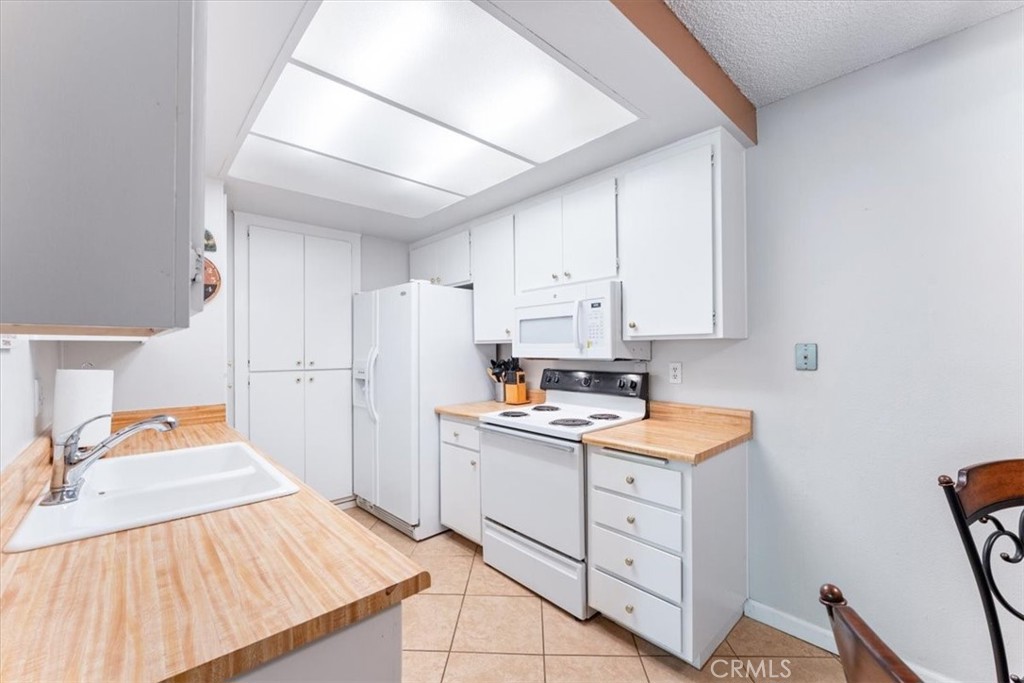 Bright white kitchen with easy care flooring. - 25611 Quail Run 32, Dana Point CA 92629 - photo 7