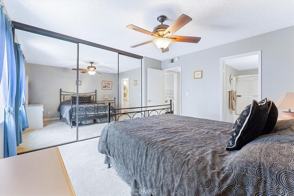 The second bedroom with mirrored wardrobe doors and a lighted ceiling fan. - 25611 Quail Run 32, Dana Point CA 92629 - photo 12