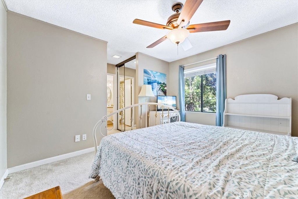 Primary bedroom has a lighted ceiling fan and the floor is carpeted. - 25611 Quail Run 32, Dana Point CA 92629 - photo 18