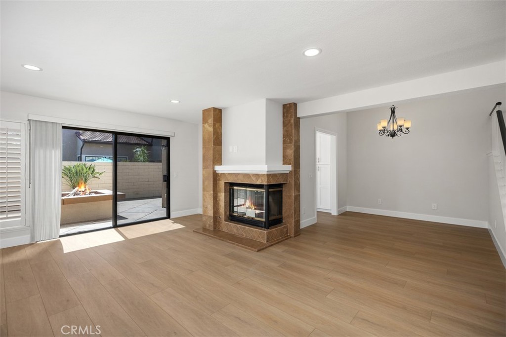 Luxury Vinyl Plank flooring throughout the first floor, with gas log fireplace and recessed living room lighting. - 25716 Harbor Point Dr. 178, Dana Point CA 92629 - photo 3