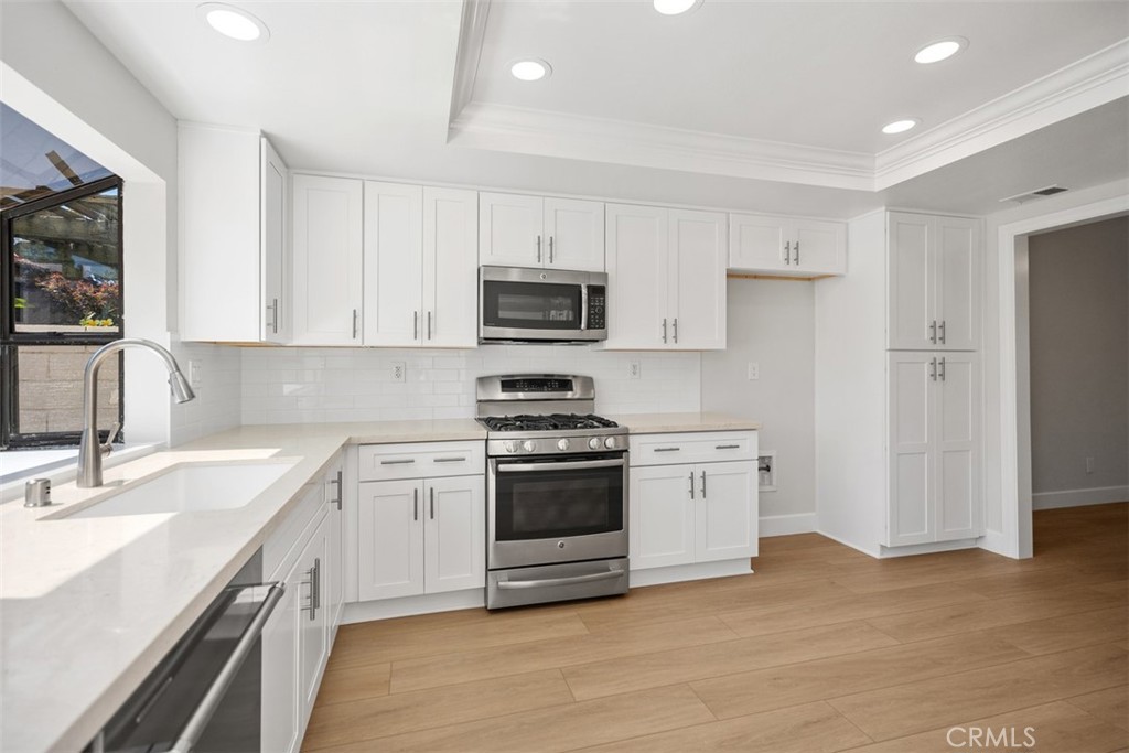 New soft close cabinets and quartz countertops, featuring a garden window and room for a kitchen dining table. Kitchen l - 25716 Harbor Point Dr. 178, Dana Point CA 92629 - photo 4