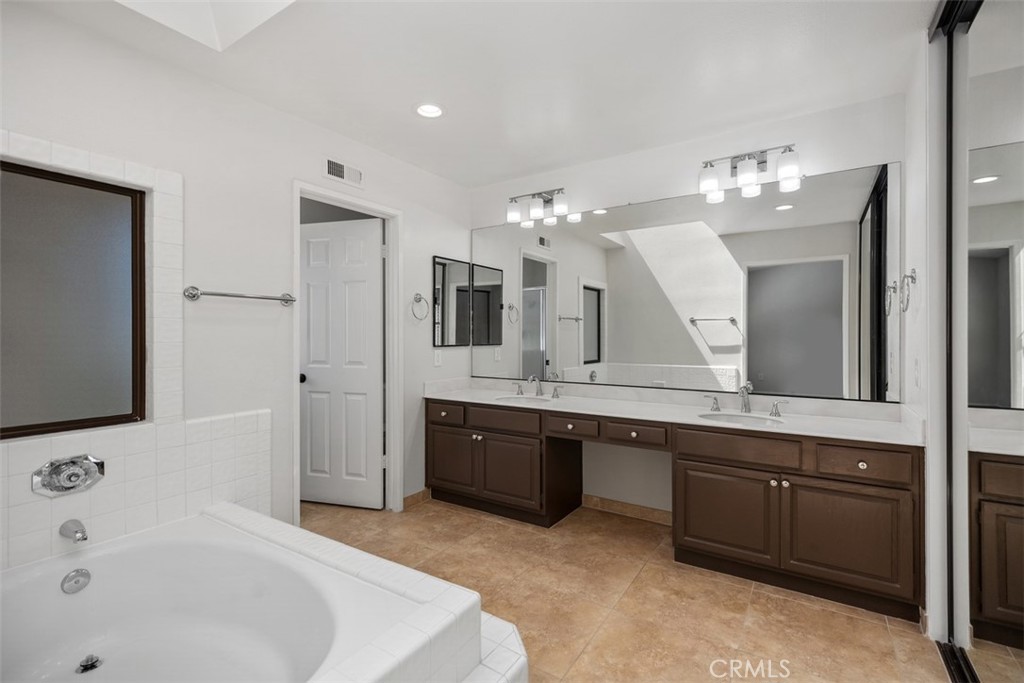 Spacious Primary bathroom with large bath tub and twin sinks & skylight ceiling window. Shower & toilet are in a separat - 25716 Harbor Point Dr. 178, Dana Point CA 92629 - photo 12