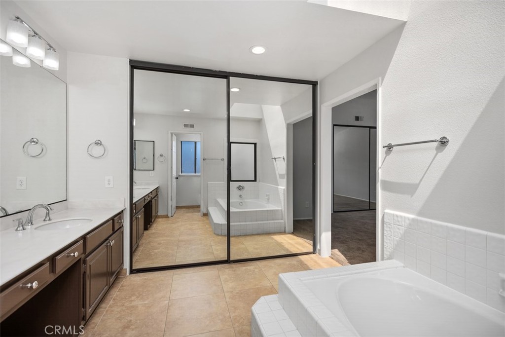Primary bathroom with tub, dual sinks, and lots of closet space! - 25716 Harbor Point Dr. 178, Dana Point CA 92629 - photo 15