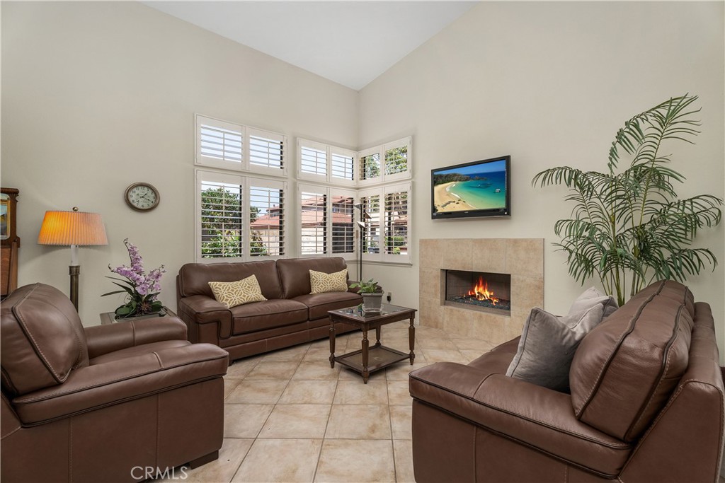 Living room fireplace with plantation shutters - 25742 Shell Drive 189, Dana Point CA 92629 - photo 8