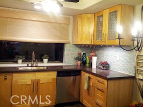 Beautiful remodeled kitchen with solid surface counters, glass back splash, stainless appliances, green house window - 25752 Oceanwood Drive 121, Dana Point CA 92629 - photo 1