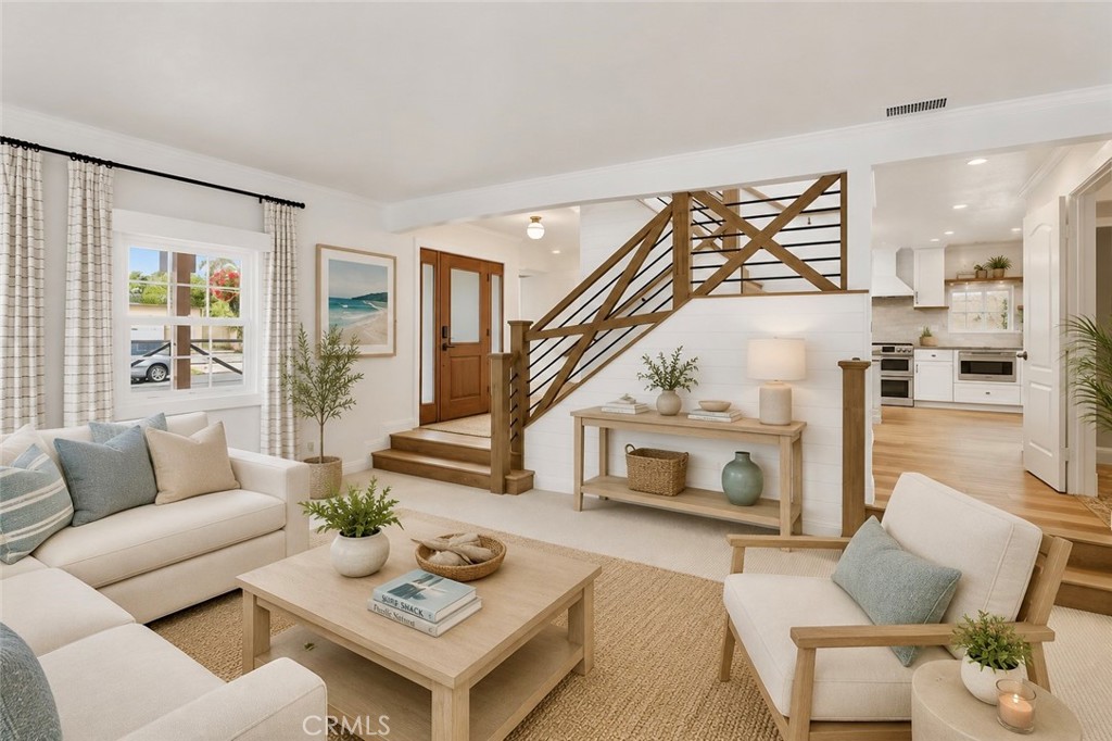front door from living room with stairway to 2nd floor decorated cozy and inviting. AI Staged - 26882 Calle Real, Dana Point CA 92624 - photo 6