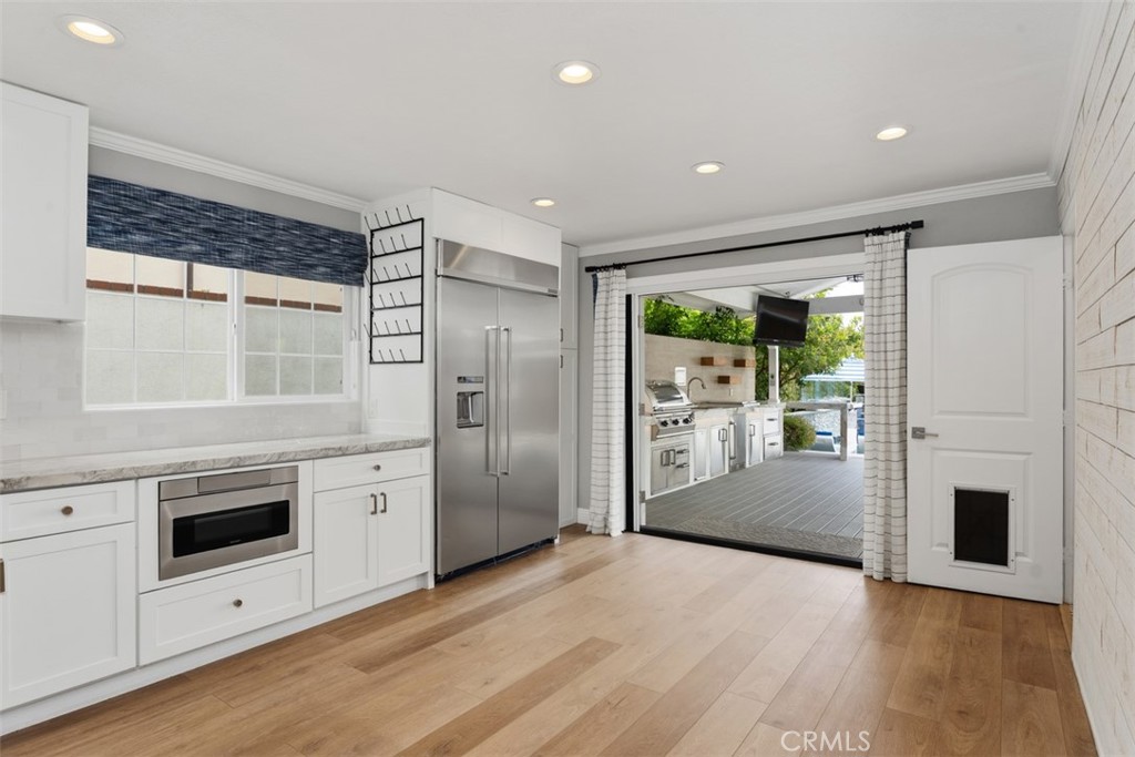 Kitchen has double door opening to a beautiful extended outdoor living space, patio/BBQ/Flatscreen tv and full kitchen. - 26882 Calle Real, Dana Point CA 92624 - photo 12