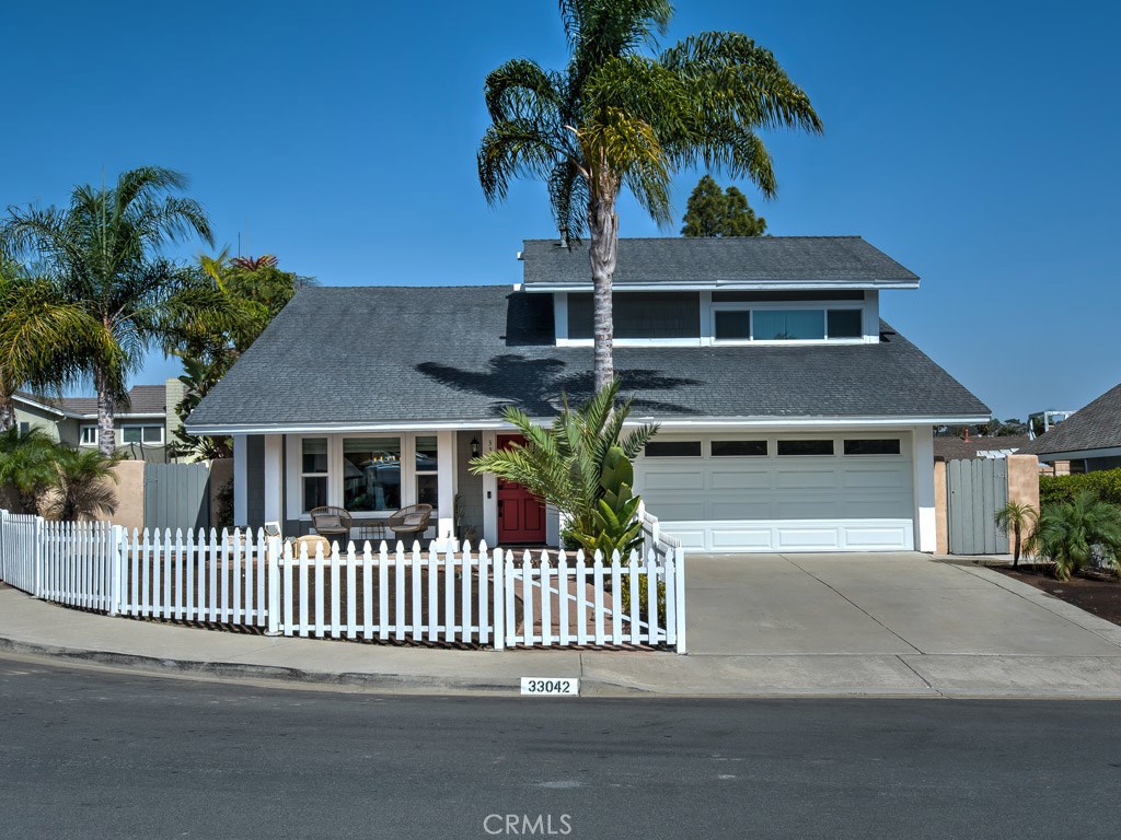 Palm trees and a white picket fence grace the front of this beautiful home as well as a garage door with windows and a d - 33042 Buccaneer Street, Dana Point CA 92629 - photo 1