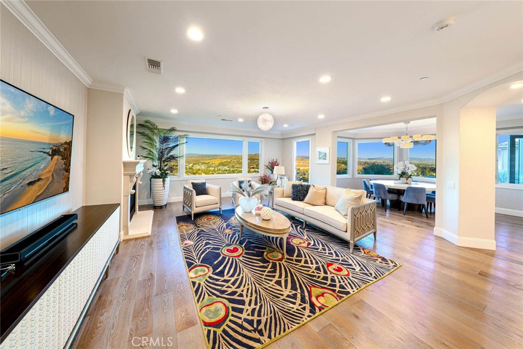 AN EXPANSIVE FAMILY ROOM HIGHLIGHTING DESIGNER SILK WALLPAPER, A GRAND FIREPLACE SURROUND, MOTORIZED BINDS/SHADES & PANO - 33612 Holtz Hill Road, Dana Point CA 92629 - photo 1