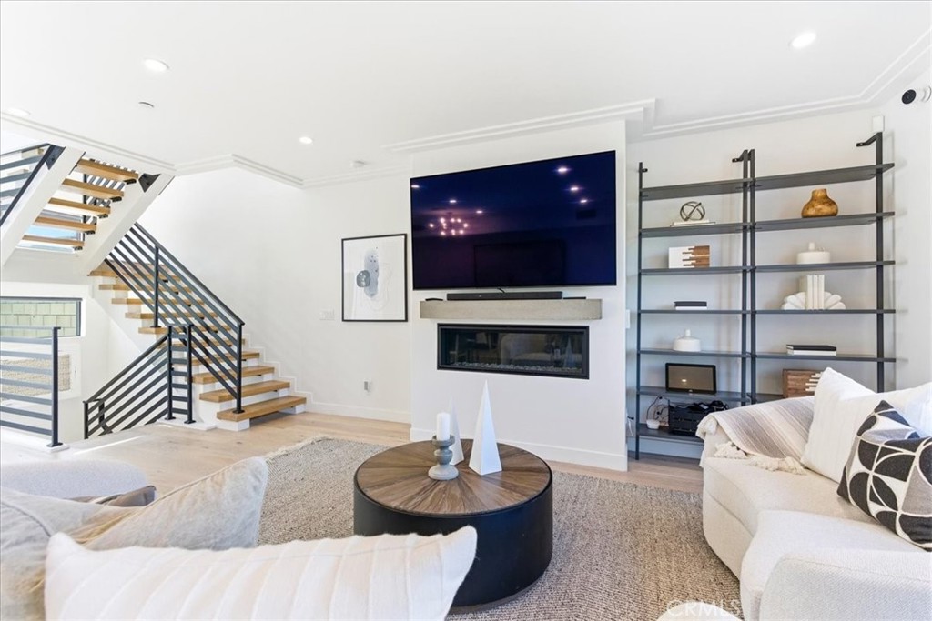 Living room view featuring a sleek fireplace, built-in display shelving, and contemporary architectural details. - 33871 Calle La Primavera, Dana Point CA 92629 - photo 12