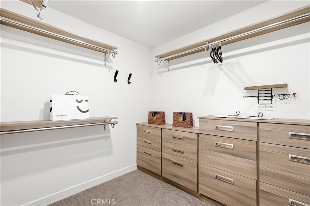 Custom dressing room with extensive built-in cabinetry, shelving, and exceptional storage solutions. - 33871 Calle La Primavera, Dana Point CA 92629 - photo 32