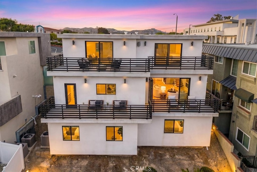 Rear of the home at dusk, with balconies on all three levels. - 33871 Calle La Primavera, Dana Point CA 92629 - photo 2