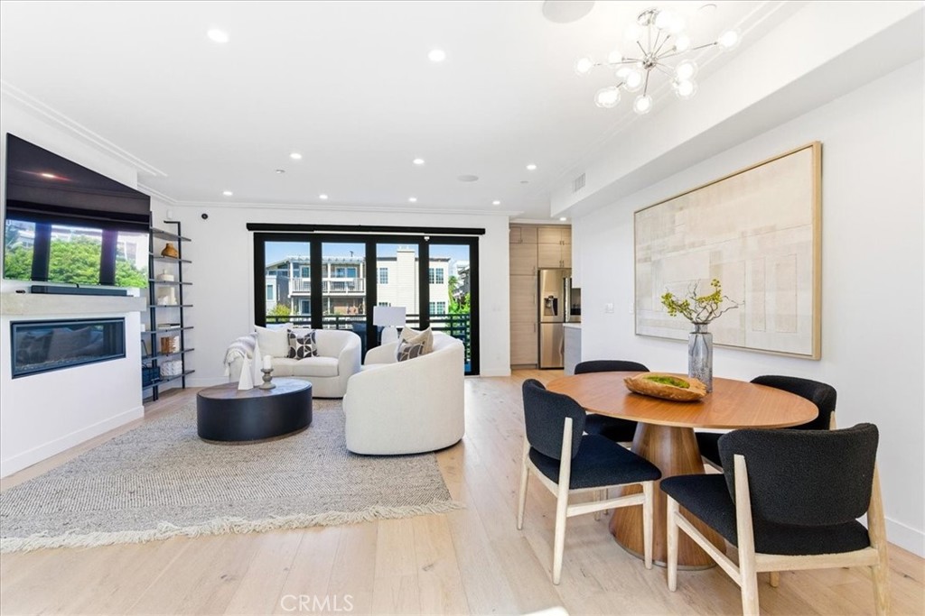 Living and dining area with a fireplace and large windows. - 33871 Calle La Primavera, Dana Point CA 92629 - photo 5