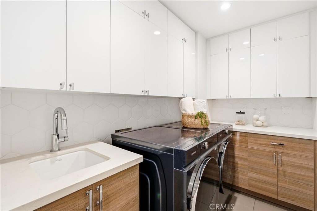 Laundry area with built-in cabinets and a sink. - 33871 Calle La Primavera, Dana Point CA 92629 - photo 19