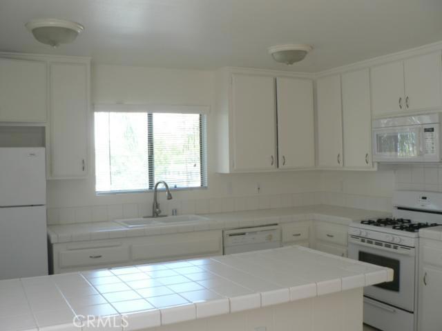 bright cheery kitchen with tile counter tops, built-in micro, gas stove/oven, counter top with eating area, dining area - 33872 Alcazar Drive, Dana Point CA 92629 - photo 1