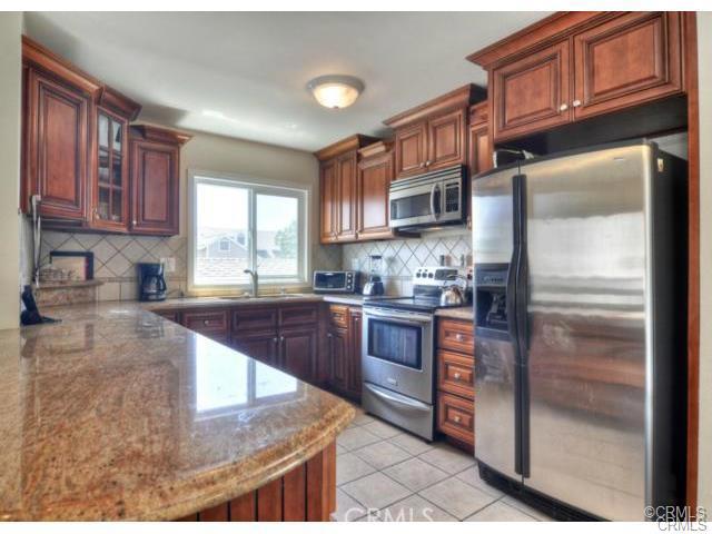 Beautifully updated kitchen with granite, s/s appliances, and large breakfast bar. - 34030 Selva Road 87, Dana Point CA 92629 - photo 1