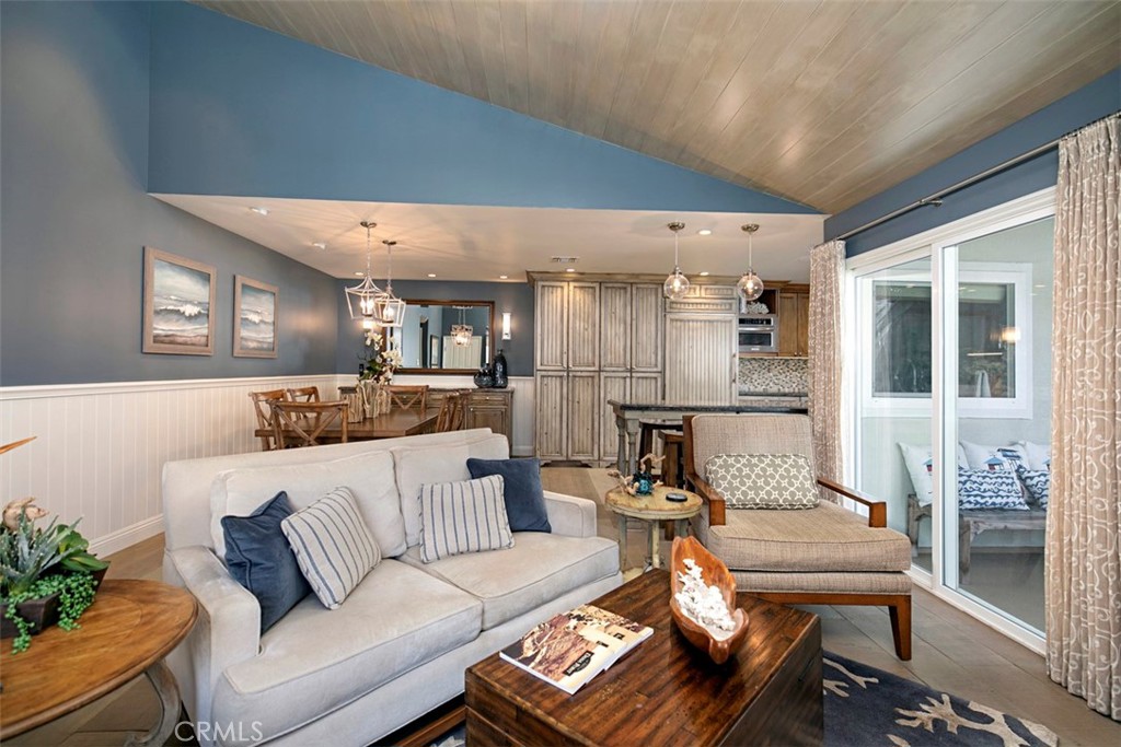 TV over fireplace and an open concept living and kitchen space with second deck off living room. - 34126 Selva Road 301, Dana Point CA 92629 - photo 5