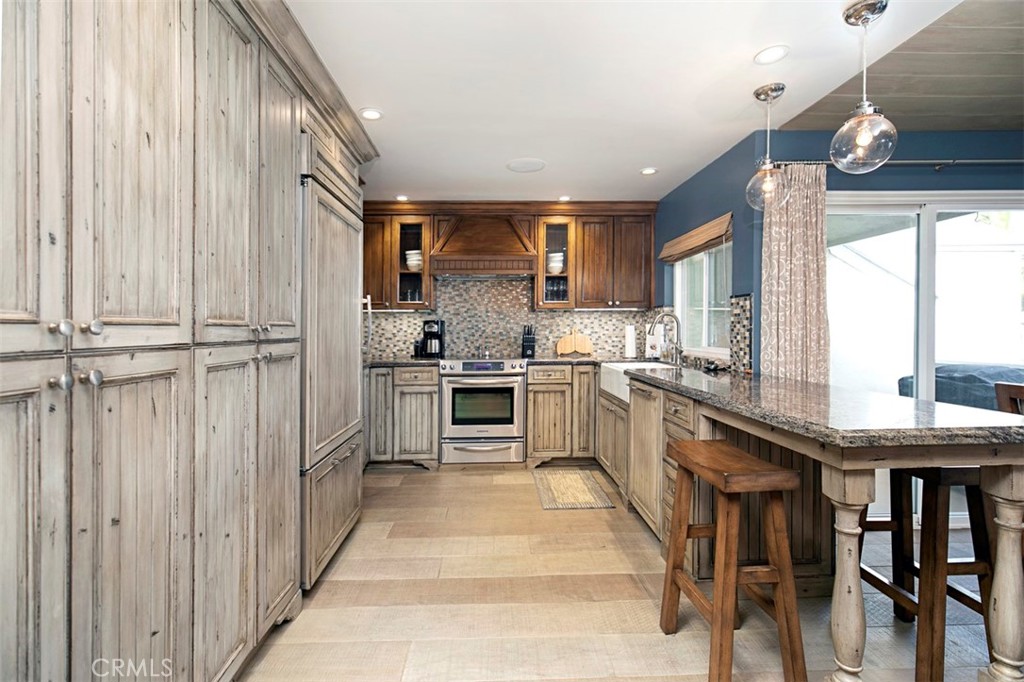 Kitchen view with pantry and washer and dryer and refrigerator behind paneled doors. - 34126 Selva Road 301, Dana Point CA 92629 - photo 7