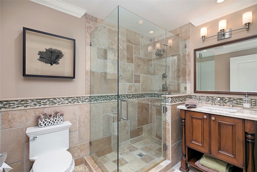 Hallway bathroom with glass enclosed shower and stonework. - 34126 Selva Road 301, Dana Point CA 92629 - photo 10