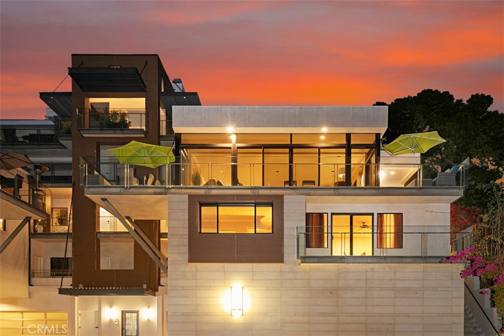 Exterior at sunset, main living area wrap around deck with umbrellas, master suite private deck on lower level. - 34403 Green Lantern Street 2, Dana Point CA 92629 - photo 1