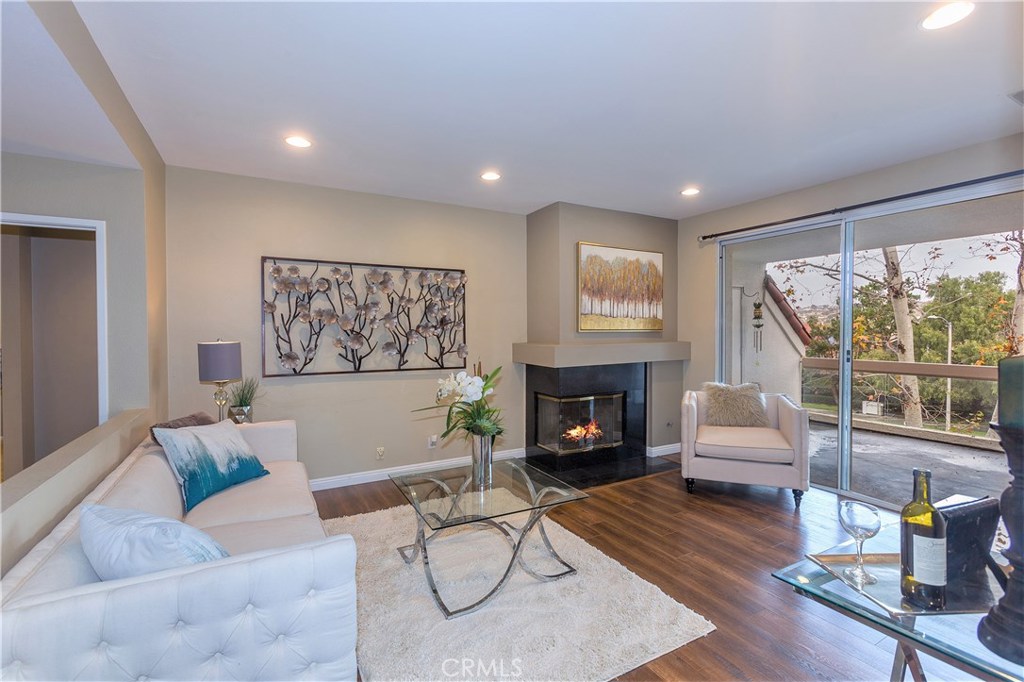 Living room with laminate flooring, lots of natural light, opening to private balcony. Recessed lights and cozy fireplac - 37 La Paloma, Dana Point CA 92629 - photo 1