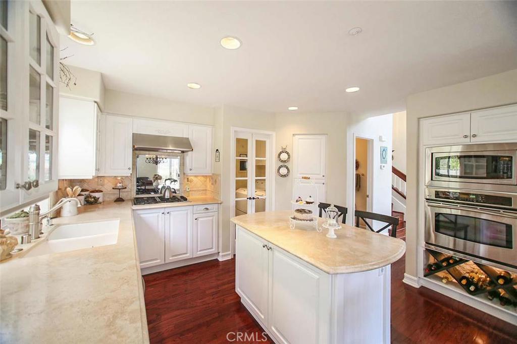 Stunning kitchen with Travertine counters, rich toned wood floors and pristine white cabinetry. - 41 Santa Lucia, Dana Point CA 92629 - photo 1