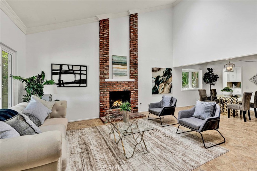 Formal living room filled with natural light, featuring vaulted ceilings and a cozy fireplace - 16029 Basil Street, Fountain Valley CA 92708 - photo 1