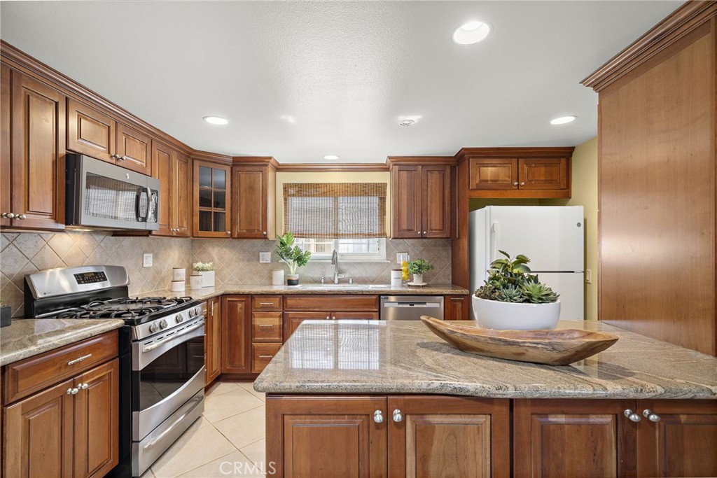 Rich cherry-toned cabinetry, a 5-burner gas range - 18474 Tamarind Street, Fountain Valley CA 92708 - photo 4