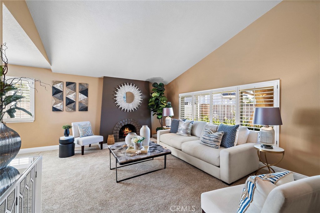 expansive living room features a vaulted ceiling, wood shutters - 18898 Persimmon Circle, Fountain Valley CA 92708 - photo 3