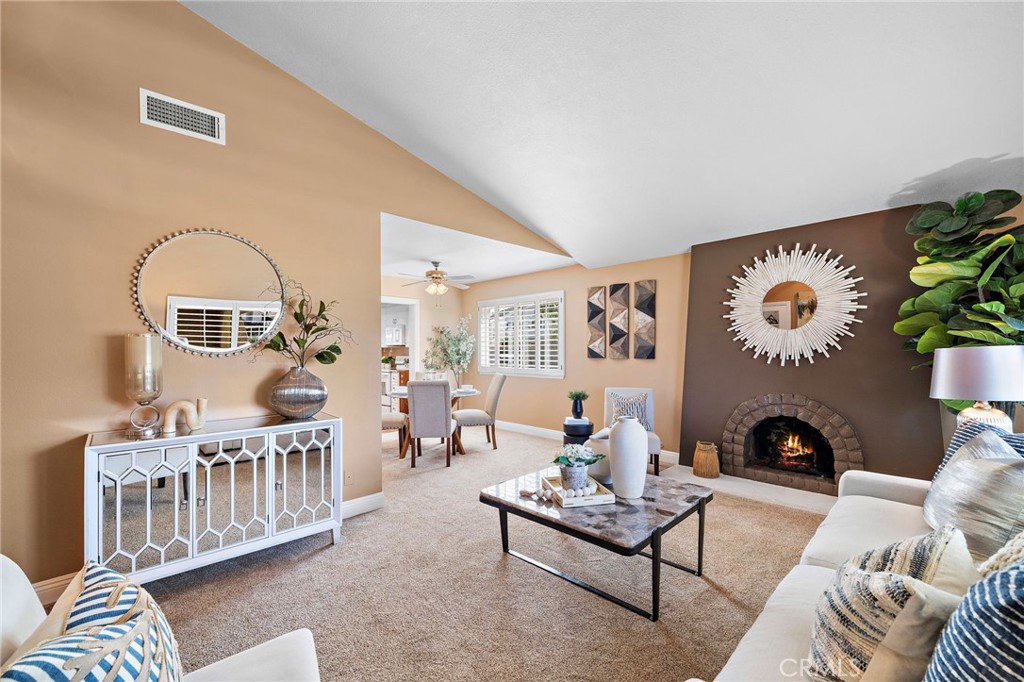 expansive living room features classic brick fireplace - 18898 Persimmon Circle, Fountain Valley CA 92708 - photo 5