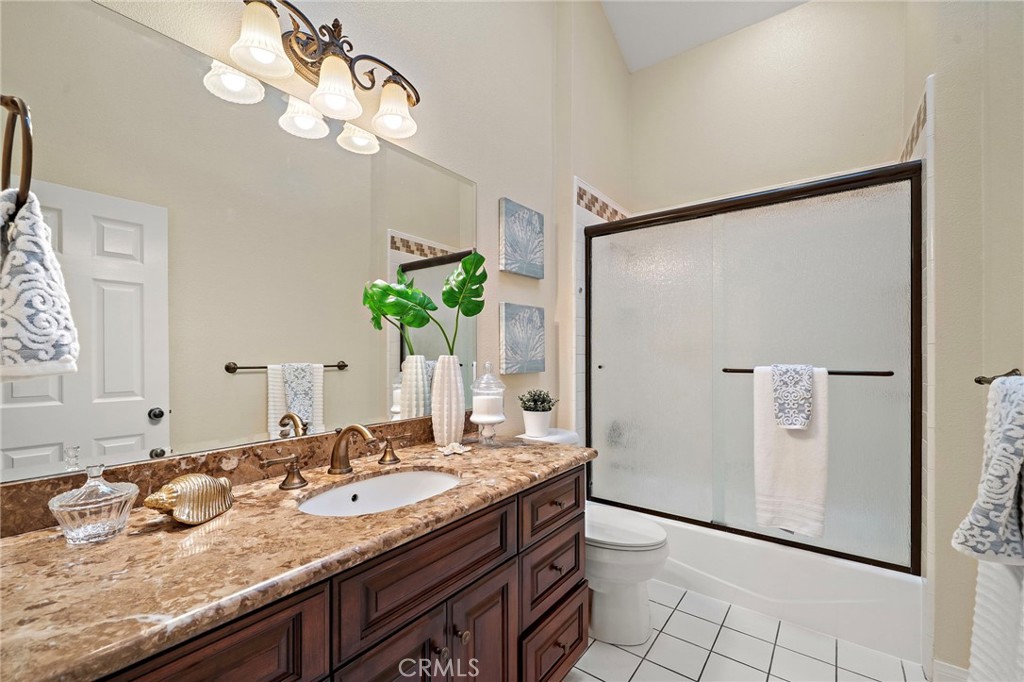 Upstairs guest bath boasts granite finishes, tiled shower, and skylight. - 8566 Phoenix Avenue, Fountain Valley CA 92708 - photo 35