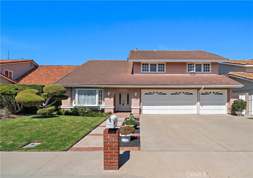 Wide driveway and three-car garage complement the landscaped front lawn - 9115 McBride River Avenue, Fountain Valley CA 92708 - photo 2