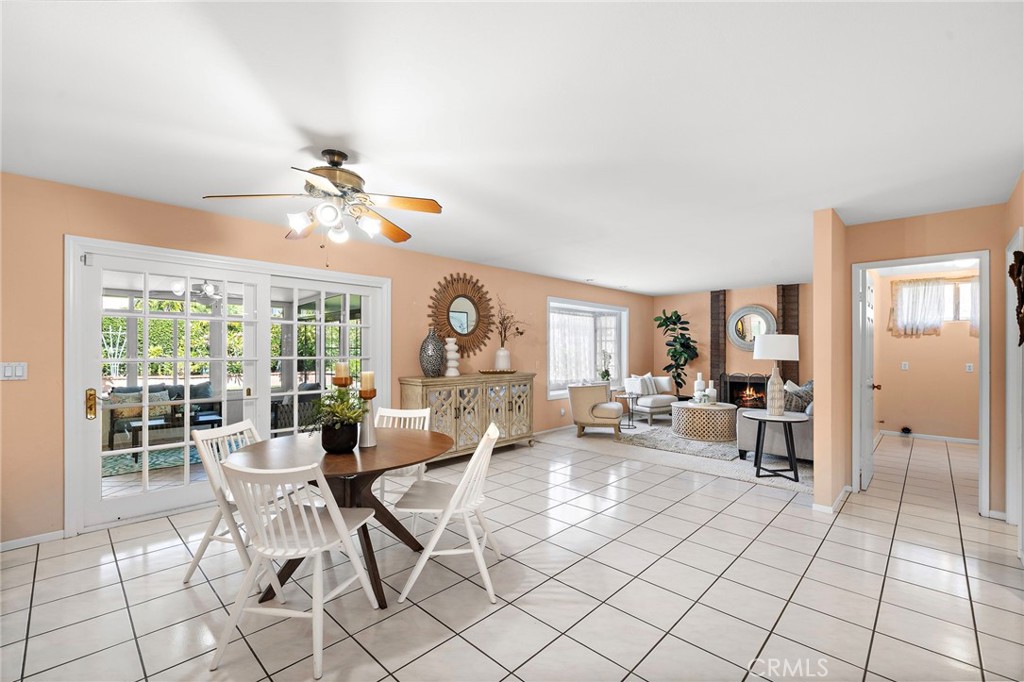Breakfast room with tile flooring flows seamlessly into the warm and inviting family room with fireplace and bay window - 9115 McBride River Avenue, Fountain Valley CA 92708 - photo 11