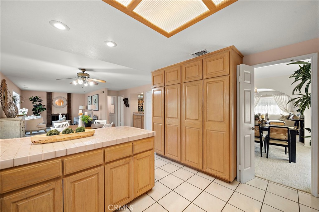 Kitchen view showing cabinetry, island, and adjoining living space - 9115 McBride River Avenue, Fountain Valley CA 92708 - photo 21