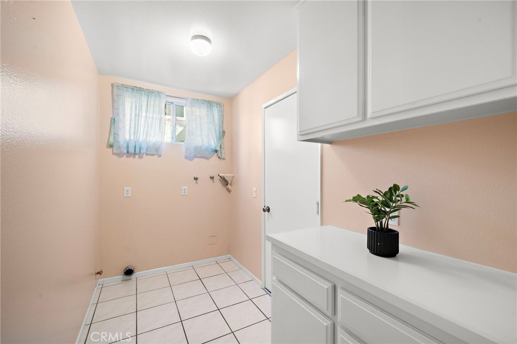 Laundry room with storage cabinetry and folding counter - 9115 McBride River Avenue, Fountain Valley CA 92708 - photo 24