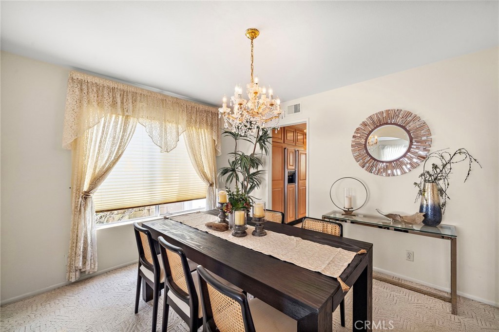 Formal dining room with chandelier lighting and a generous window. - 9115 McBride River Avenue, Fountain Valley CA 92708 - photo 8