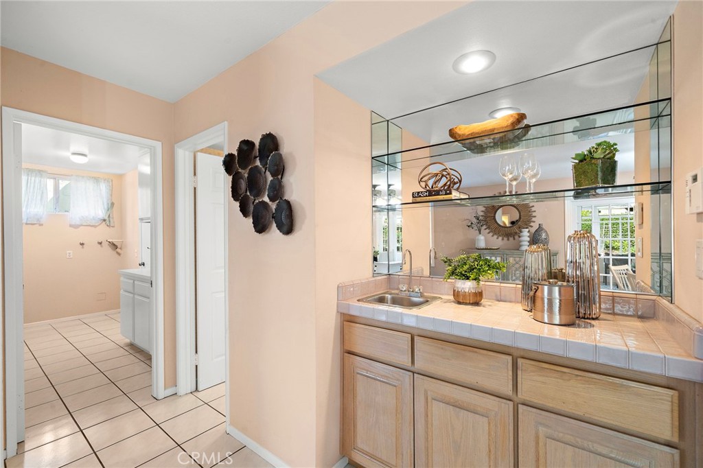 Kitchen counter and glass-front cabinetry add display and serving space. - 9115 McBride River Avenue, Fountain Valley CA 92708 - photo 22