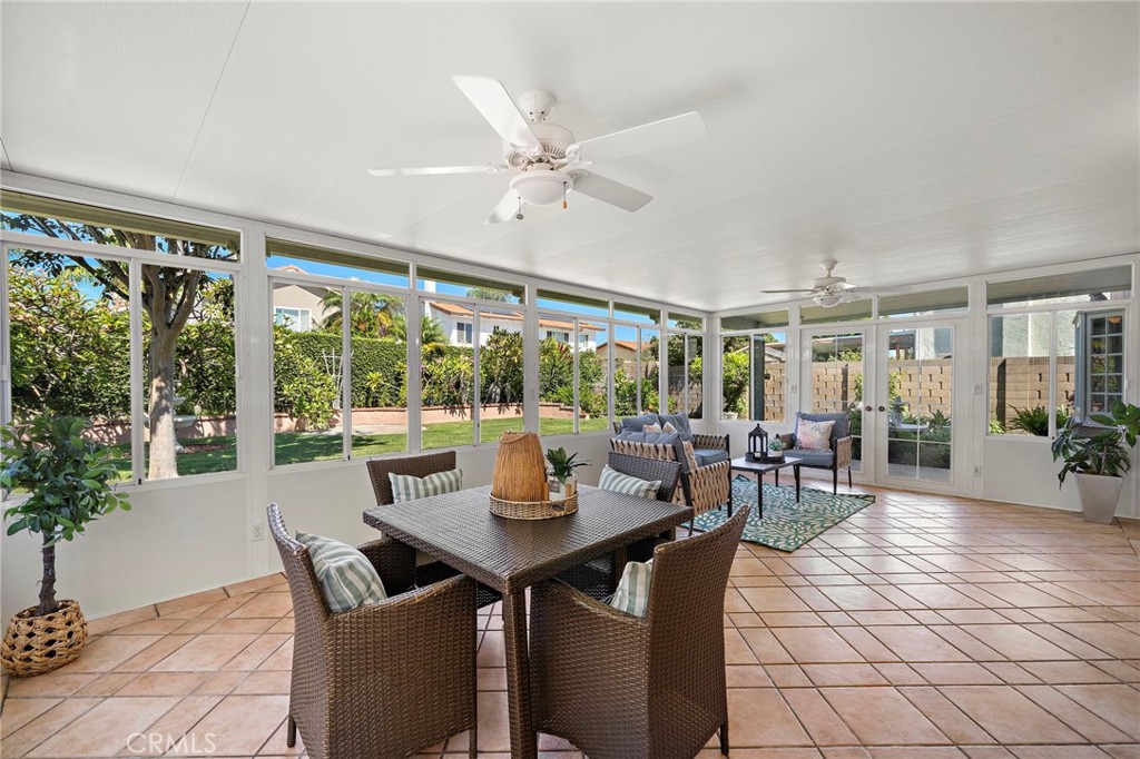 Sunroom dining area surrounded by windows and garden views. - 9115 McBride River Avenue, Fountain Valley CA 92708 - photo 28