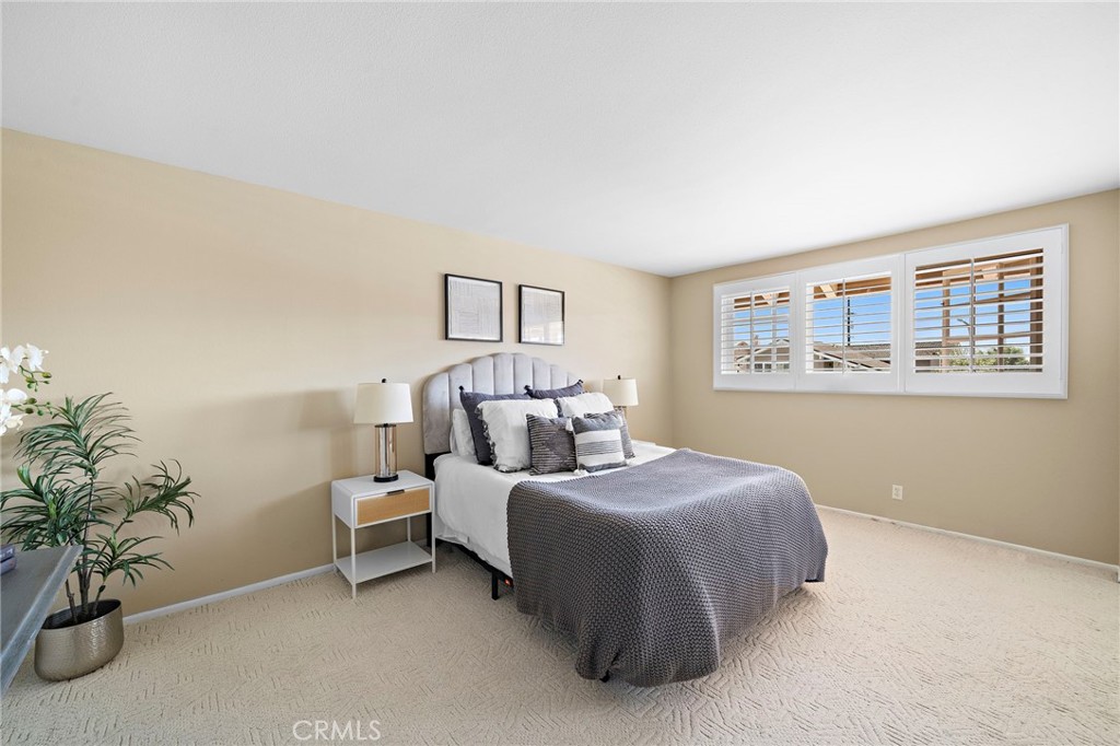 Bright bedroom with a broad window and mirrored closet doors. - 9115 McBride River Avenue, Fountain Valley CA 92708 - photo 33