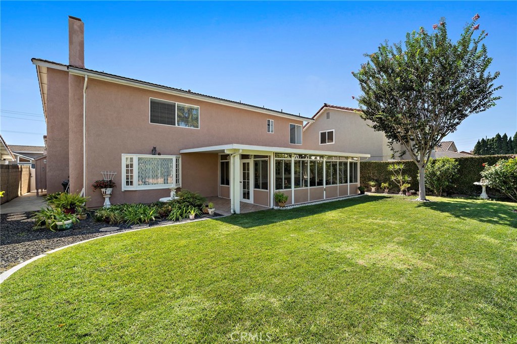 Rear exterior showcases the sunroom and generous backyard. - 9115 McBride River Avenue, Fountain Valley CA 92708 - photo 44