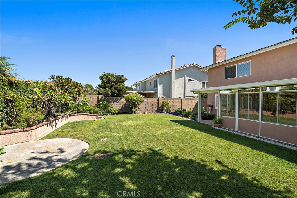 Inviting backyard with lawn, garden beds and a paved patio. - 9115 McBride River Avenue, Fountain Valley CA 92708 - photo 46